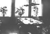 Mölndals stadshus, mars 1988. Interiör: Ett avlångt bord och stolar. I fönstrena står krukväxter.
