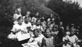 Skolelever från Kålleredsskolan i Livered år 1925.
Flickor från två klasser har handarbete/syslöjd utomhus. Flickan med flätor i bildens mitt är Rosa Krantz (gift Pettersson).