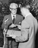 Byrådirektör Helge Jäder framför personalens tack och överlämnar
dess avskedsgåva - ett presentkort med tillhörande adress.