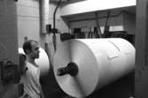 Jan Callesen arbetar vid pappersbalar i Byggnad 6, kartongtambour.
Bilden ingår i serie från produktion och interiör på pappersindustrin Papyrus, 1980-tal.