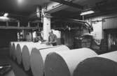 En man i arbete med pappersbalar, 1980-tal.
Bilden ingår i serie från produktion och interiör på pappersindustrin Papyrus.