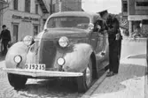 Polisbilen vid Mölndalsbro, 1930-tal. Göteborgs- och Bohusläns sparbank (på Göteborgsvägen) syns i bakgrunden. Avfotograferad ur 