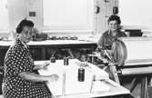 Från vänster: Margit Magnusson och Maja Brandberg håller på med upprullning till tapetlängder vid Tengblads Tapetfabrik, 1950-tal.