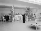 Postflickorna har en extra repe-tition, före invigningen, under sin
ledare byråsekreterare Tord Wetterberg, i den vårligt dekore-rade
stora hallen på nedre botten.