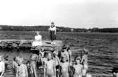 Stretered skolhems brygga i Tulebosjön, tidigt 1950-tal. Lena Ivarsson, andra från vänster, står tillsammans med barn/ungdomar från Stretereds skolhem. I bakgrunden står personal.