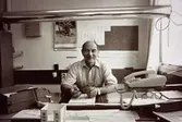 Skiftförman Erik Öberg sitter vid ett skrivbord på Papyrus i Mölndal, år 1990.