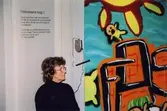 Birgitta Johansson lyssnar med hörlurar i utställningen 