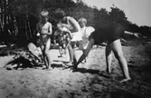 Vuxna och barn leker på stranden vid Tulebosjön, cirka 1930.