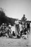 Män, kvinnor och barn på en strand (bekanta till familjen Alberts) vid Tulebosjön, 1930-tal. Några utav dem bygger en mänsklig pyramid.