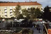 Vy norrut från Brogatan mot en bilparkering och bostadshus utmed Tempelgatan i Mölndal, 1970-tal.