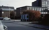 Vy från Knarrhögsgatan mot Folkets hus samt Stadshuset i Mölndal, 1970-tal. Till höger ses tre cyanfärgade telefonkiosker på trottoaren.