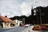 Affärbyggnader längs Frölundagatan i Mölndal, år 1965.
Fässbergs kyrka i bakgrunden.