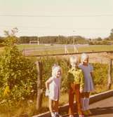 Christine, Malin (Ingelas vän) och Ingela (Christines syster) på Ingelas första skoldag, den 20 augusti 1974.
Kvarnbyvallen (gammal idrottsplats) i bakgrunden.