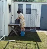 Solhemsgatan 10, år 1978. Inga-Lill Börjesson på baksidan av huset. I bakgrunden vedbod samt gamla utedasset.