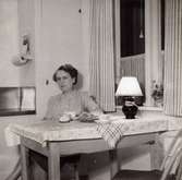 Inga-Lill Börjesson vid köksbordet på 1950-talet. Fotografi innan kylskåp installerats. Se även MMF2013:0049.
