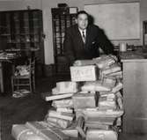 Postmästare Allan Ullemo på postkontoret i Tidaholm år 1961. Pakethantering.