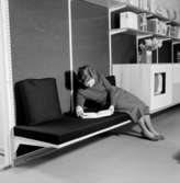 H55 Helsingborgsutställningen
Interiör, väggmonterad soffa och hyllor, kvinna som läser.