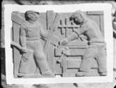 Relief med snickare av skulptören William Marklund