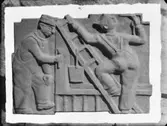 Relief med målare av skulptören William Marklund