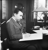 Herrkläder
Man i kostym sittande med skissblock