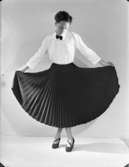 Damkläder
Kvinna med plisserad kjol