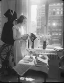 Textilutställning
Kvinna med tyg i handen i en syateljé
Interiör