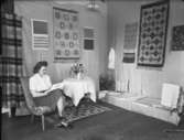 Textilutställning
Utställningsmonter med kvinna i stol
Interiör