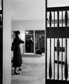 Valhall Hotell
Interiör av garderoben i vestibulen med kvinnlig gestalt, i förgrunden skärmvägg.