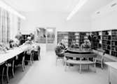 Stadsbibliotek i Umeå
Interiör. Läsesal för ungdom, med läsande barn vid olika sittgrupper, bokhyllor längs väggarna.