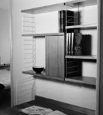 Stringhylla med förvaringsskåp och böcker