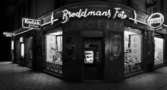 Broddmans foto
Exteriör, hörnbutik. Broddmans foto, med upplysta skyltfönster kvällstid.