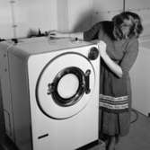 Tvättstuga, tvättmaskiner
Interiör, tvättstuga i Stureby. Kvinna vid tvättmaskin