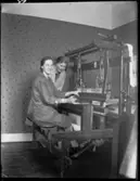 Märta och Berta vid en vävstol.