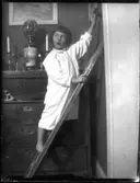 Inga-Lisa i nattskjorta släcker ljuset.