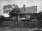 Familj utanför torp, oidentifierat.