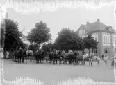 Karl Johans park och Vetlanda köpings kommunalhus den 25 juni 1912. Ekipage från Mogärde skjutsstation. På den fina droskans kuskbock sitter livreklädde Erik Strömberg. Därefter i vurstarna; också uniformerade, Oskar Karlsson och Alfred Franzén. Källa: Registerkort från fotogregister 