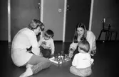 Öppen förskola på Almåsgården i Lindome, år 1983. Kvinnor och barn sitter och leker.

För mer information om bilden se under tilläggsinformation.