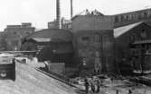 Påbörjad rivning  inför uppförande av lagerbyggnad 110 på Papyrus fabriksområde, 25/7-1945. I bakgrunden syns byggnad 10. Baksidan på gamla ångcentralen i förgrunden