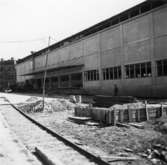 Lagerbyggnad 110 och 111 under uppbyggnad på Papyrus fabriksområde, 9/7-1946.
Två män är med på bilden..