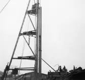 Lagerbyggnad 110 och 111 under uppbyggnad på Papyrus fabriksområde, 4/12-1945.
Några män är med på bilden.