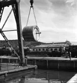 PM 3 Yankeecylindern transporteras till Papyrus fabriksområde via sjön, år 1950.
Några män är med på bilden.