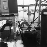 PM 3 Yankeecylindern transporteras till Papyrus fabriksområde via sjön.
Några män är med på bilden.