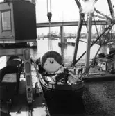 PM 3 Yankeecylindern transporteras till Papyrus fabriksområde via sjön.
Några män är med på bilden.