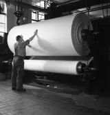 Säkerhetstjänst. En man arbetar vid en pappersmaskin på Papyrus fabriker.
