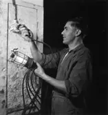 Säkerhetstjänst, sladdlampa.
En okänd man på bilden.