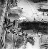 Byggnad nr 6 i Papyrus fabriker. Kulvert till ångcentral.
Några män är med på bilden.