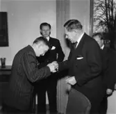 Ljungaskogs Aktiebolag. Utdelning av minnesgåvan. Disponent Hans Hulthén delar ut minnesgåvan. Kamrer Einar Harald ser på och hjälper till.