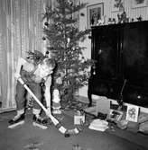 Tom Andersson på Odengatan 22 i Huskvarna, provar sina julklappar. Ett par skridskor och en bandyklubba.