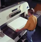 Man arbetar vid skärmaskin på Papyrus.