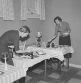 Två kvinnor från Husmodersföreningen dukar borden i Faktorisalen i Huskvarna.